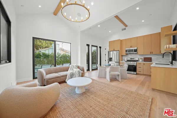 a living room with furniture a fireplace and a floor to ceiling window