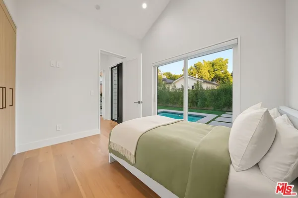 a bed sitting in a bedroom next to a window