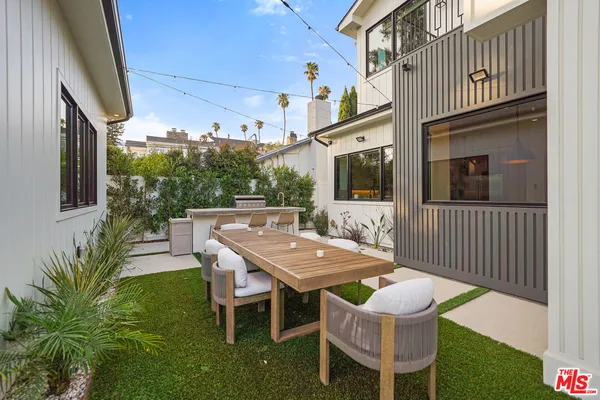 a view of a patio with table and chairs and potted plants with wooden floor