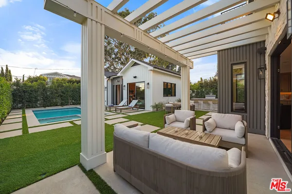 a view of a patio with couches table and chairs and garden view