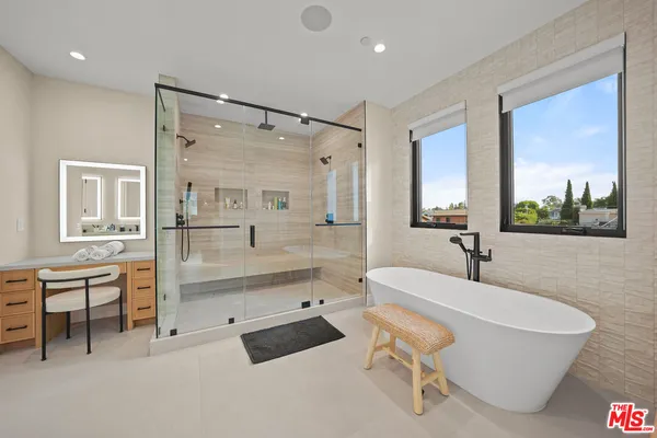 a bathroom with a tub a sink and mirror