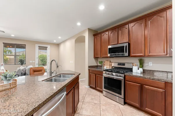 a kitchen with stainless steel appliances granite countertop a sink dishwasher stove and microwave
