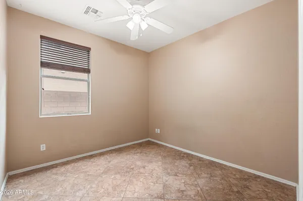 an empty room with windows and fan