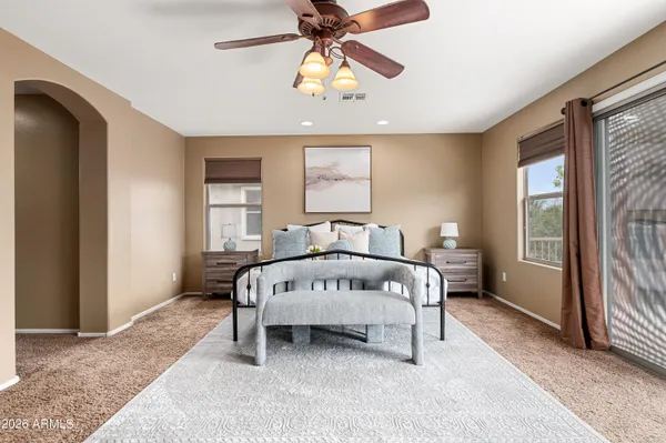 a bed sitting in a spacious bedroom next to a window