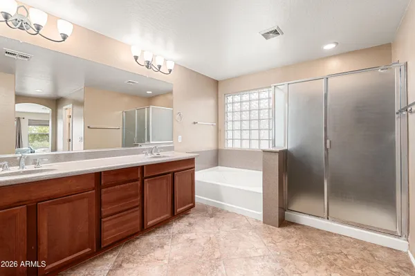 a spacious bathroom with a tub sink shower and mirror