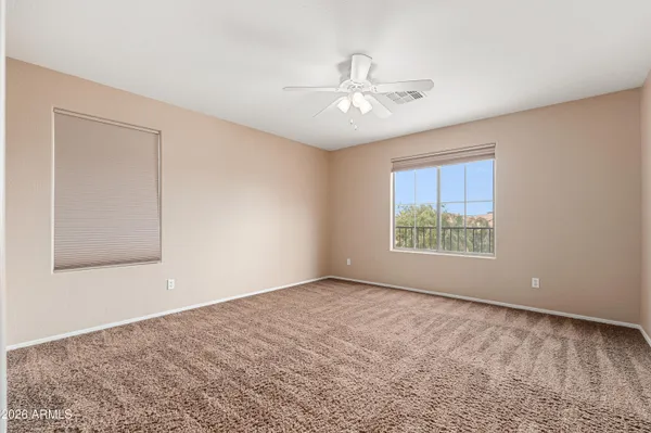 an empty room with windows and fan