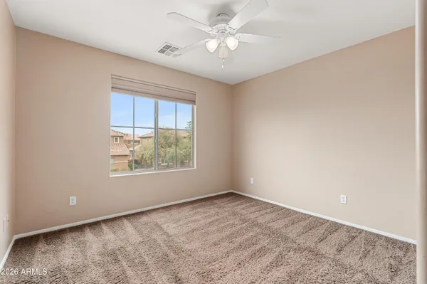 an empty room with windows and ceiling fan