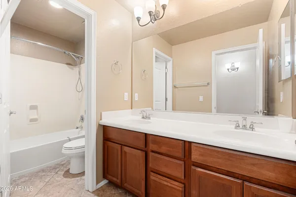 a spacious bathroom with a granite countertop sink toilet and shower