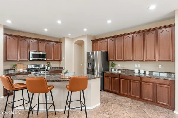 a kitchen with stainless steel appliances granite countertop a refrigerator and a stove top oven