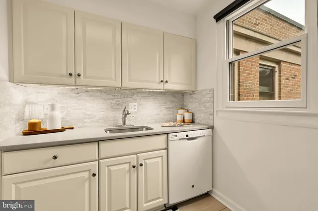 a kitchen with stainless steel appliances granite countertop white cabinets and a sink
