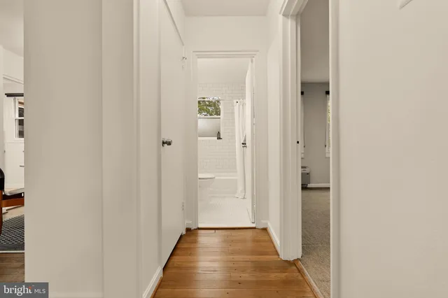 a view of a hallway with wooden floor