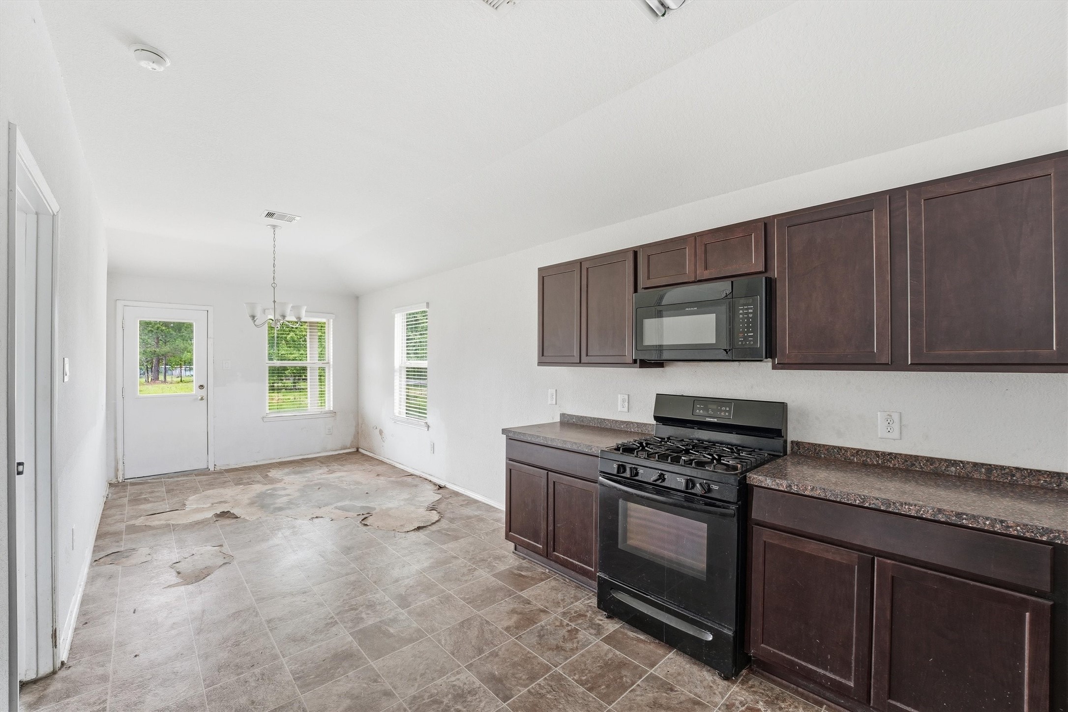 1634 Road 5102 Cleveland, TX 77327 - Photo 10 of 21 a kitchen with granite countertop a stove a sink and a microwave