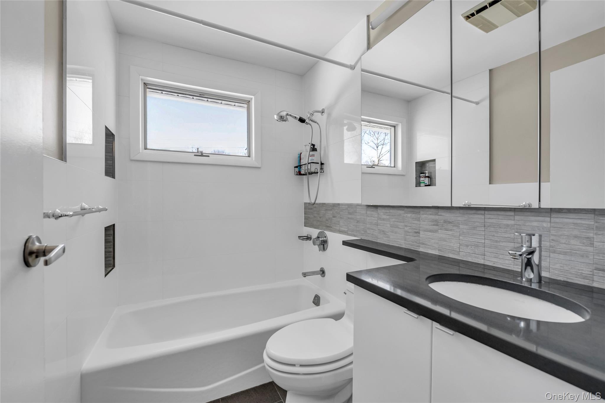 34 Roxbury Road Port Washington, NY 11050 - Photo 11 of 18 a bathroom with a granite countertop sink toilet and shower
