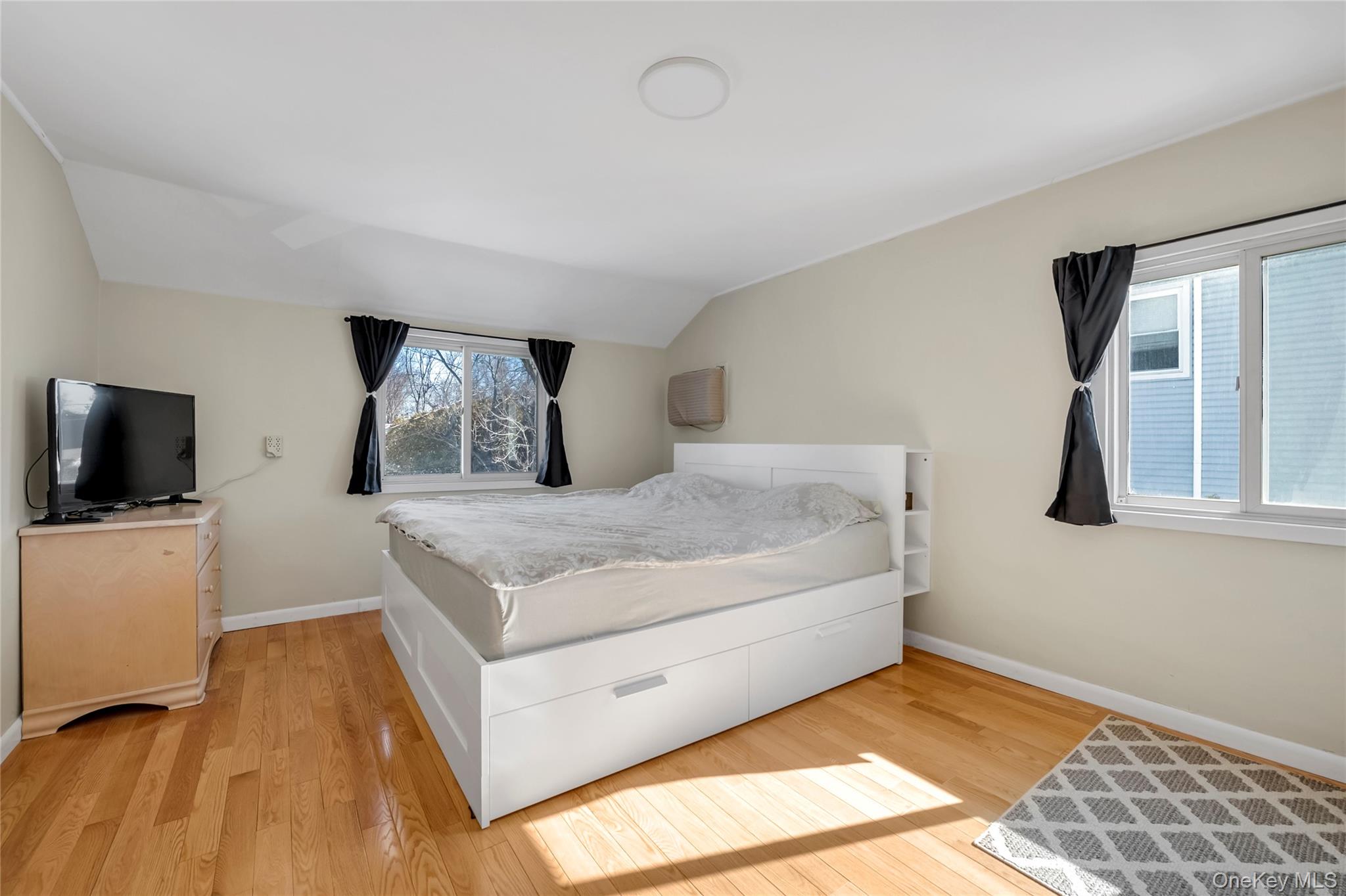 34 Roxbury Road Port Washington, NY 11050 - Photo 13 of 18 a living room with a bed furniture and a flat screen tv