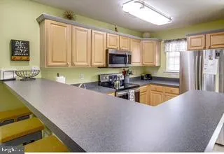 a kitchen with stainless steel appliances granite countertop a sink a stove and a refrigerator