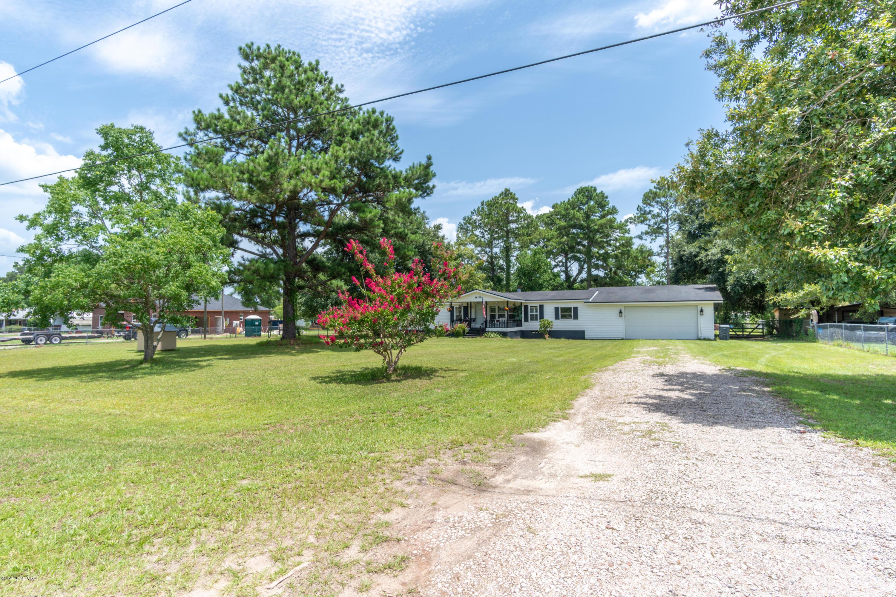 54256 Dornbush Road Callahan, FL 32011 - Photo 2 of 60 a front view of a house with a yard and trees