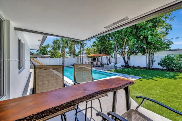 a view of a patio with table and chairs with wooden floor and fence