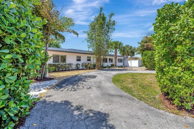 a white house with a yard and wooden fence