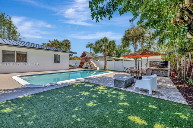 a backyard of a house with table and chairs