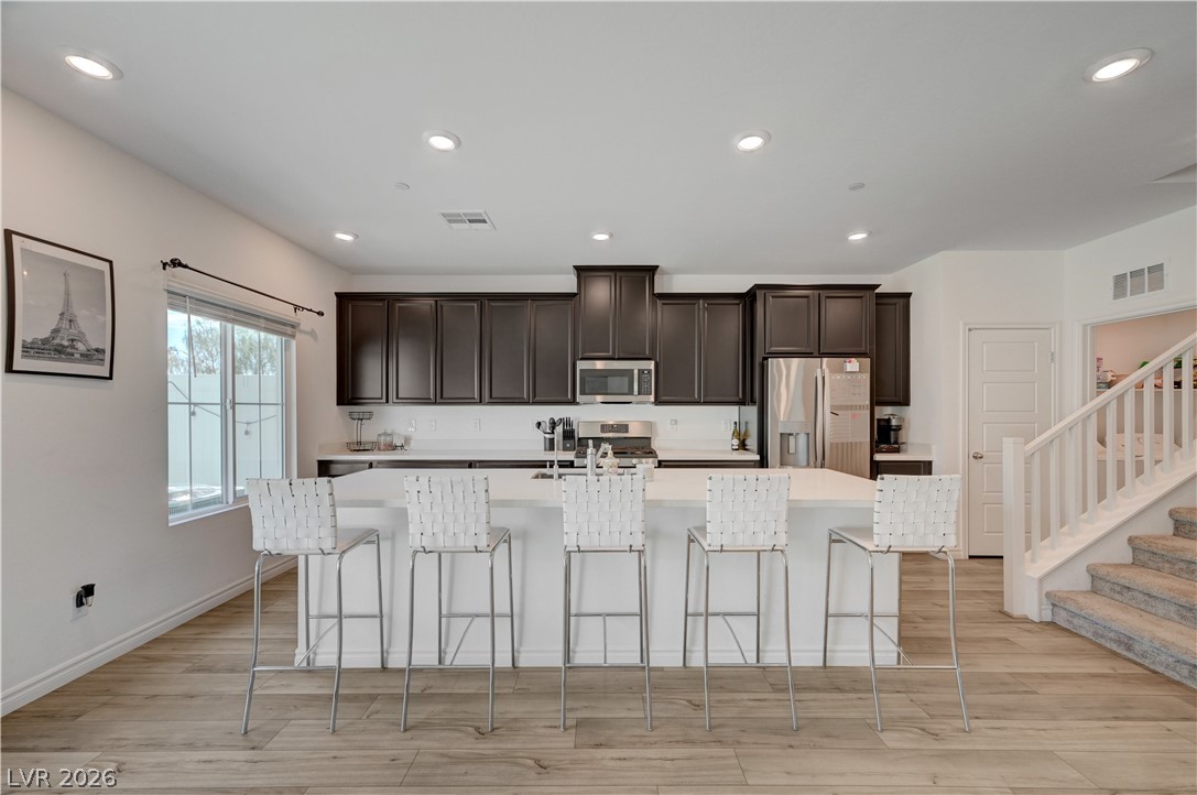 7204 North Decatur Boulevard, Unit 3 North Las Vegas, NV 89084 - Photo 1 of 48 A contemporary kitchen showcasing rich cabinetry, sleek countertops, and an inviting island with casual seating.