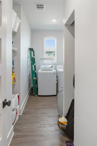 a view of a room with wooden floor washer and dryer
