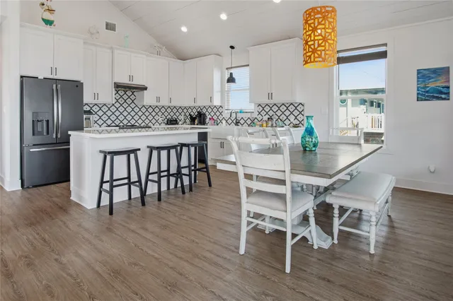 a kitchen with stainless steel appliances granite countertop a kitchen island hardwood floor and a sink