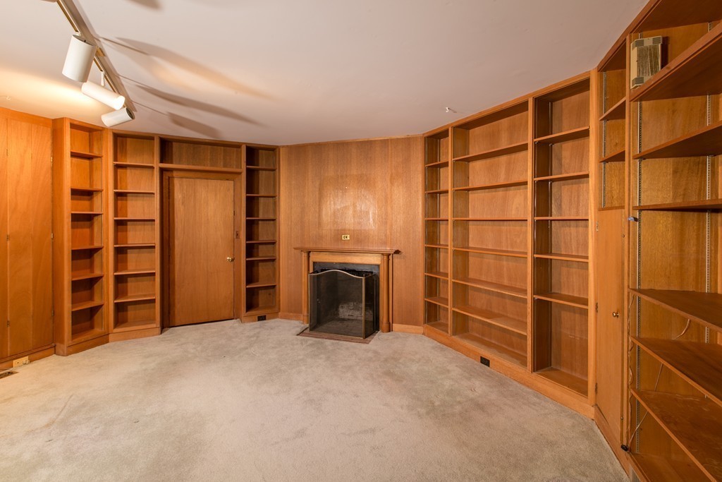 111 Barretts Mill Road Concord, MA 01742 - Photo 12 of 29 a view of an empty room with a fireplace and cabinets