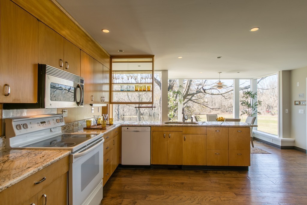 111 Barretts Mill Road Concord, MA 01742 - Photo 9 of 29 a kitchen with stainless steel appliances a sink window and cabinets