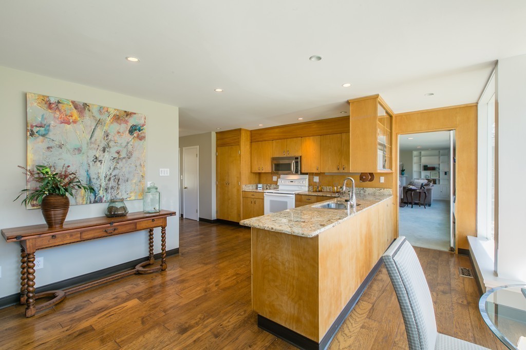 111 Barretts Mill Road Concord, MA 01742 - Photo 10 of 29 a large living room with stainless steel appliances kitchen island granite countertop furniture and a wooden floor
