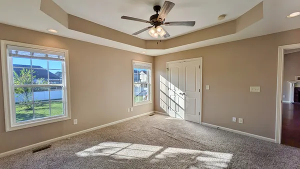 a view of a livingroom with a ceiling fan and kitchen space