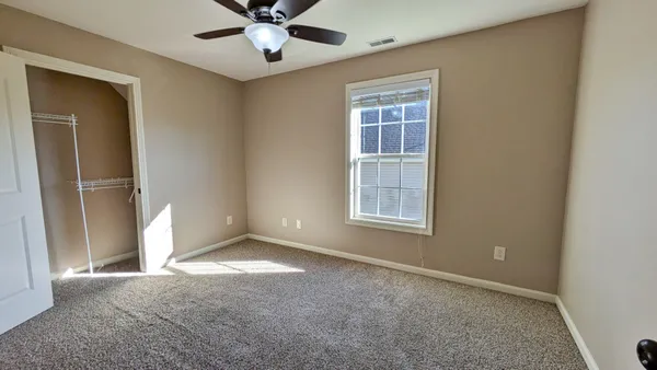 an empty room with a ceiling fan and a fan