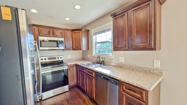 a kitchen with stainless steel appliances granite countertop a sink stove and microwave