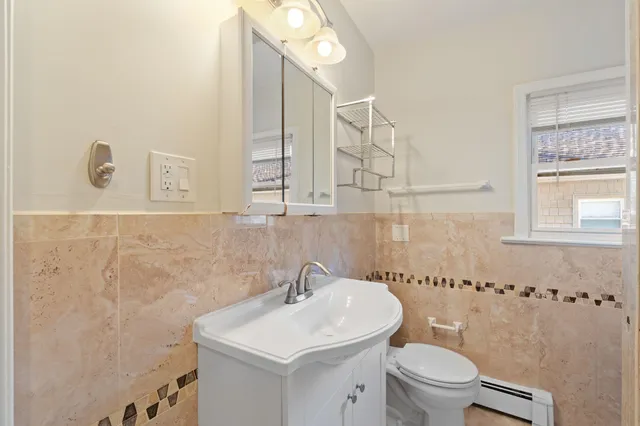 a bathroom with a sink a toilet and mirror