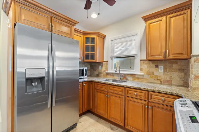 a kitchen with stainless steel appliances granite countertop a refrigerator a sink and dishwasher