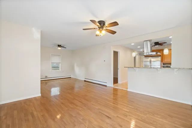 a view of a kitchen with wooden floor and a ceiling fan