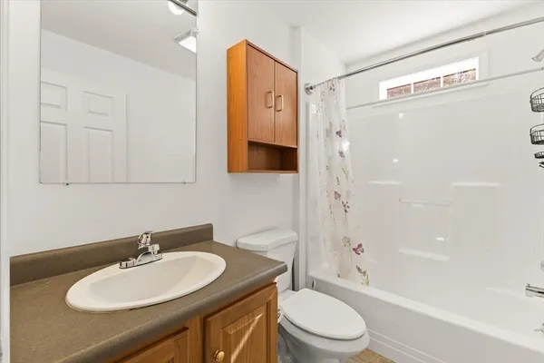 a bathroom with a granite countertop sink toilet a mirror and shower