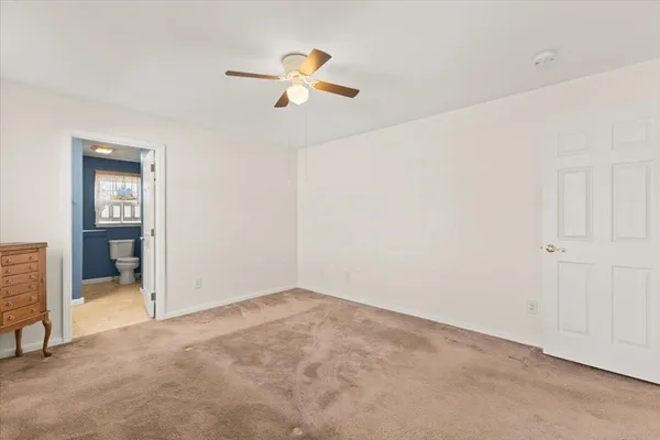 an empty room with closet and windows