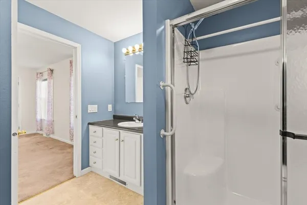 a view of bathroom with a shower and closet