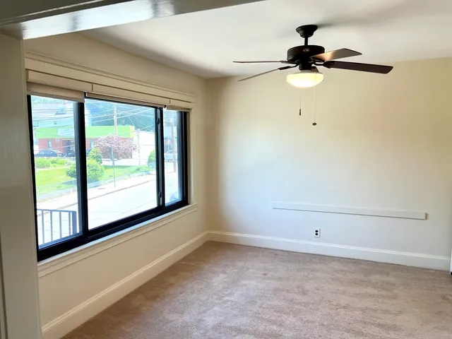 a view of a room with a window and a ceiling fan