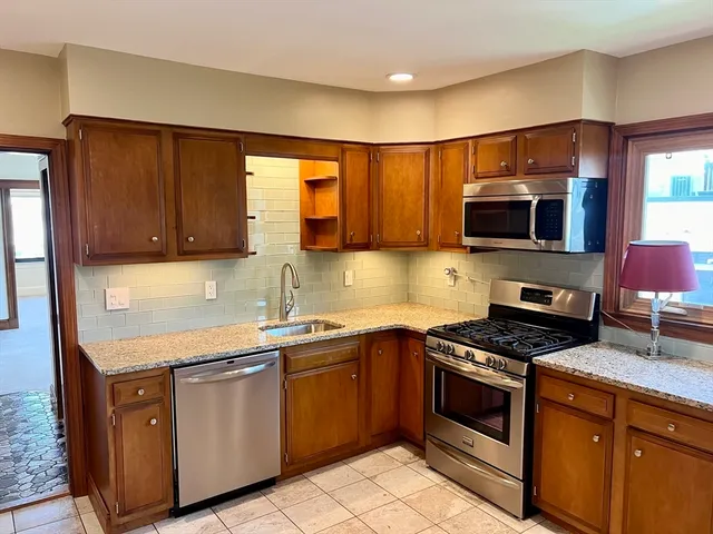 a kitchen with stainless steel appliances a stove sink and microwave