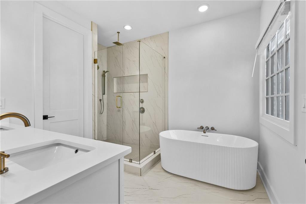 339 Sugarview Road Sugar Hill, GA 30518 - Photo 27 of 53 a bathroom with a white bath tub a sink and a mirror