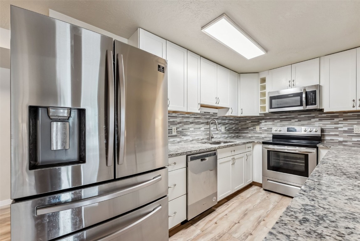 535 Straight Creek Drive, Unit 104 Dillon, CO 80435 - Photo 5 of 30 a kitchen with granite countertop a refrigerator stove and microwave