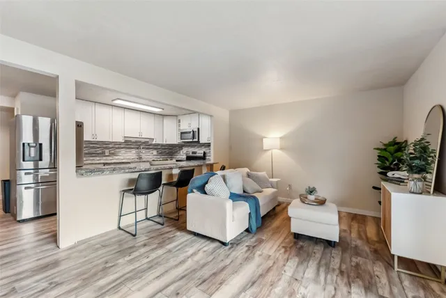 a living room with furniture and kitchen view