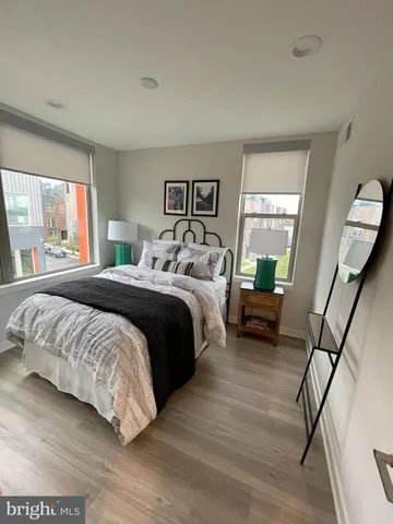 a bedroom with a bed a mirror and a window