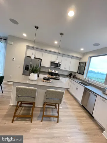 a kitchen with a sink cabinets and wooden floor