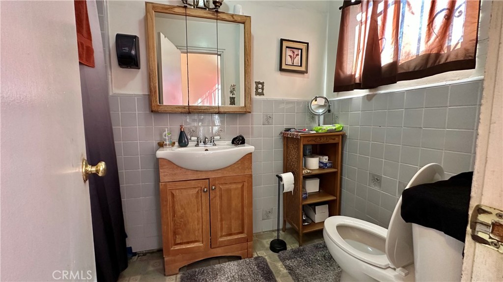 407 South Vancouver Avenue Los Angeles, CA 90022 - Photo 11 of 24 a bathroom with a toilet sink and mirror