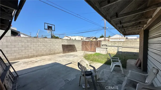 a view of a patio with table and chairs with wooden floor and fence