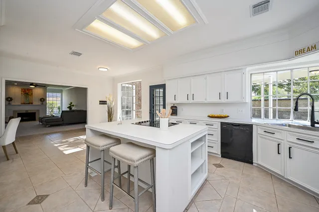 a kitchen with a sink a stove a refrigerator and chairs