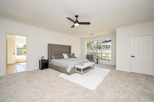 a spacious bedroom with a large bed and a chandelier