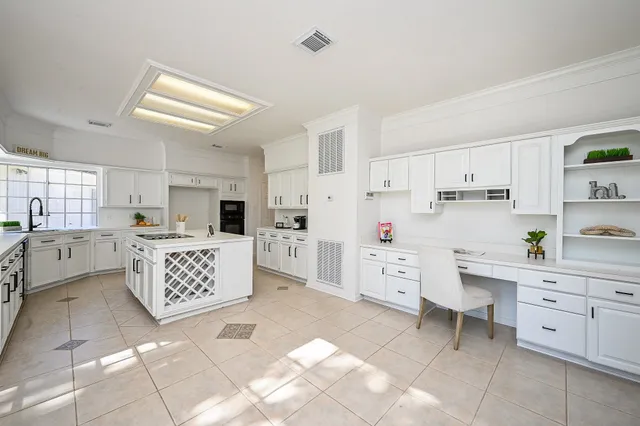 a large white kitchen with cabinets